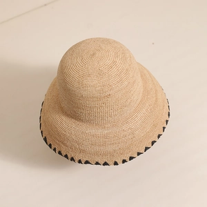 Handwoven raffia sun hat with black zigzag brim detail for beach vacations and summer wear