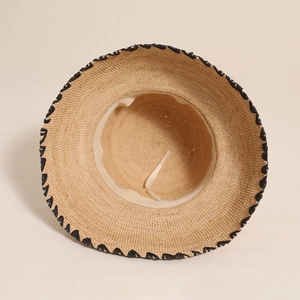 Handwoven raffia straw sun hat with black scalloped trim for beach vacation and sun protection