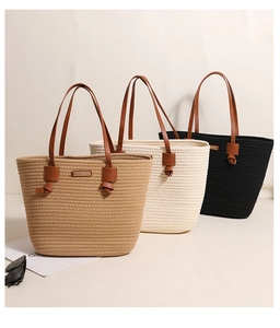 Detail of woven cotton tote bags in khaki and cream with brown leather handles