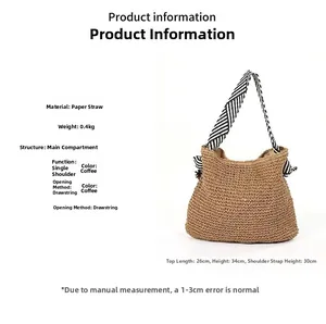 Detail showing woven straw tote bag dimensions with black and white striped shoulder strap