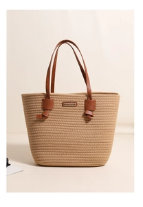 Detailed texture of cotton woven tote with leather handles and metallic logo plate