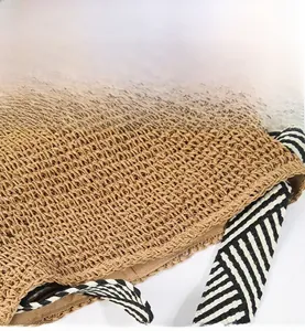 Detailed close-up of woven straw texture with wavy edge and striped ribbon accents