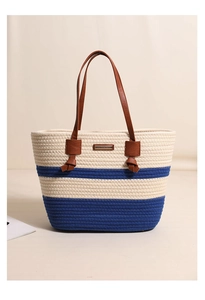 Detailed view of woven cotton striped tote with navy accents and brown leather handles