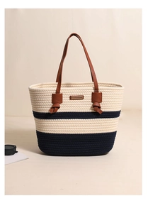 Detail of woven cotton stripe tote bag showing brown leather handles and textured knit fabric