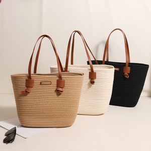 Three large woven cotton tote bags with leather handles in khaki, cream, and black