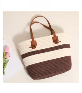 Detail of striped cotton woven tote bag with brown faux leather knot handles and texture