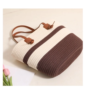 Detail of striped cotton woven tote featuring leather handles and textured knit pattern