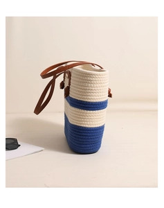 Detail of blue and white striped woven tote bag with brown leather strap and sunglasses