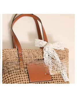 Detail shot of the woven straw tote bag featuring mesh hollow design and lace bow accent
