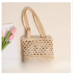 Détails des motifs en tricot ajouré faits main sur un sac de plage en raphia beige