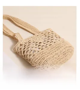 Gros plan détaillé sur la texture du fond et le tissage ajouré du sac en paille raphia
