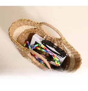 Top view of spacious straw tote interior holding books, sunglasses and accessories