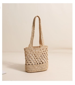 Détail du sac à bandoulière en raphia avec motif ajouré et fond tissé renforcé