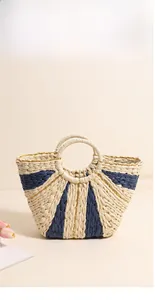 Close-up of the fan-shaped woven straw bag with khaki and navy blue contrast stripes