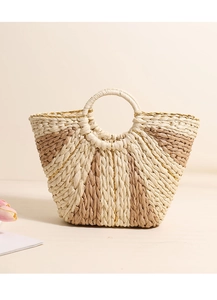 Detail of hand-woven straw tote with golden thread trim and circular top handles