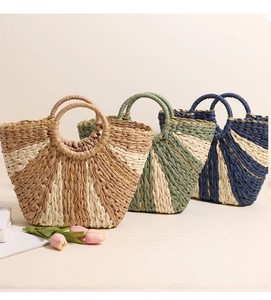 Detailed view of handmade woven straw tote bags in green, beige and navy blue colors