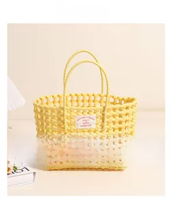 Close-up of bright yellow woven plastic beach bag with brand label and round handles