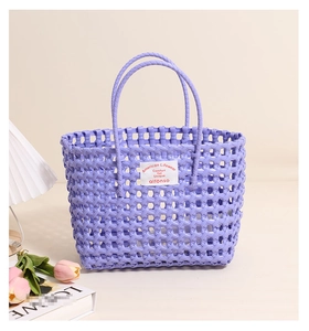 Detailed view of purple hollow woven beach bag with round handles and brand label