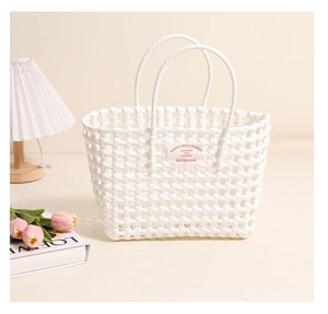 Detail of white hollow woven plastic tote bag with fabric logo tag in a cozy setting