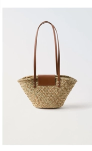 Close-up of woven straw texture with brown leather flap and silver rivet details