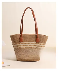 Detail showing the fine straw weave texture and brown leather handle of the striped tote bag