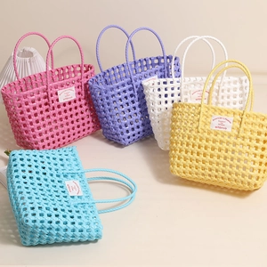 Colorful set of five waterproof woven plastic beach bags with stylish fabric labels