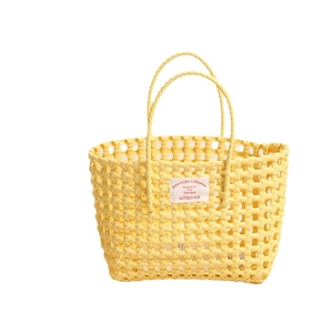 Bright yellow hollow woven plastic beach tote bag with thin double handles and label