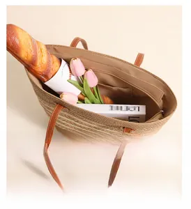 Spacious interior of striped woven straw tote bag holding books and baguette