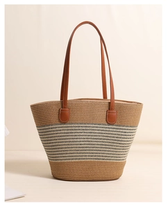 Close-up of the natural woven straw texture and faux leather handle detail on tote