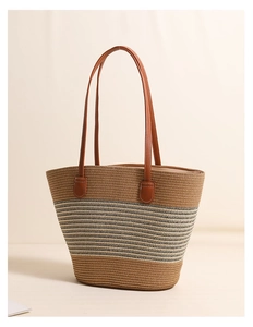Close-up of striped straw tote bag showing woven texture and brown faux leather straps