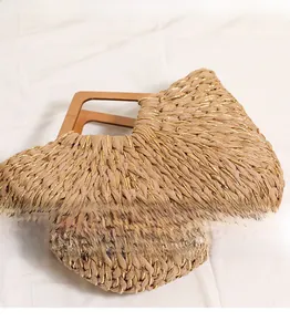 Detail showing the mixed gold silk weave and square wooden handle of this straw beach bag