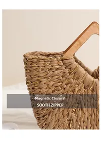 Close-up of woven straw handbag featuring gold thread, wooden handle and magnetic closure