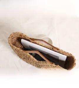 Detail view of woven straw beach bag with wooden handle showing internal storage capacity