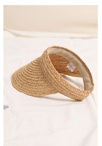 Detailed view of handmade raffia sun hat showing inner sweatband and 100% natural fiber label