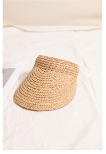 Detailed view of hand-woven raffia textures on an open-top sun hat for summer vacations