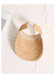 Top view of hand-woven raffia sun visor with detailed spiral weave texture