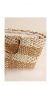 Detailed close-up of woven checkerboard texture and natural bamboo handle on beach bag