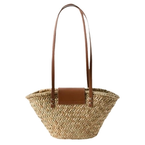 Natural straw woven tote bag with brown PU leather handles and flap closure for beach vacations