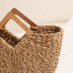 Handmade woven straw tote bag with wood handle and gold silk threads for summer vacation