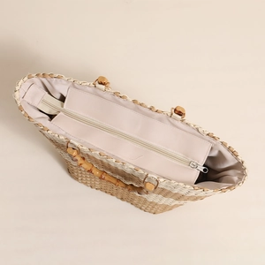 Checkered straw tote bag with bamboo handles and zipper closure for beach vacations