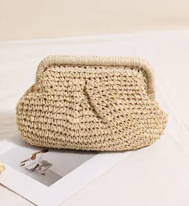 Close-up of pleated beige straw woven clutch bag with textured fabric detail
