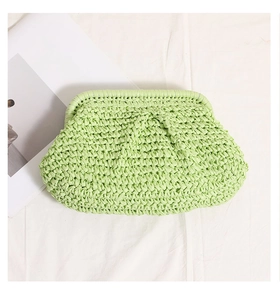 Detailed top view of mint green straw woven clutch bag on white textured fabric