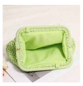Close-up of light green woven cloud clutch bag showing metal frame and inner lining