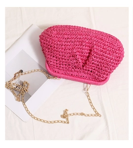 Detail of fuchsia woven crossbody bag with pleated texture and gold metal chain strap