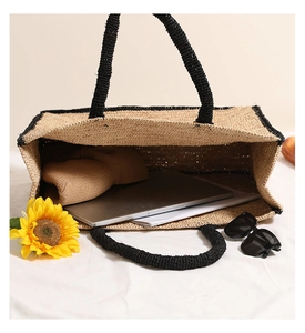 Top view of large straw tote bag with black trim showing spacious interior for beach items