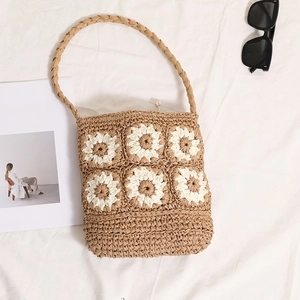 Handwoven straw shoulder bag with white flower details and beach vacation style