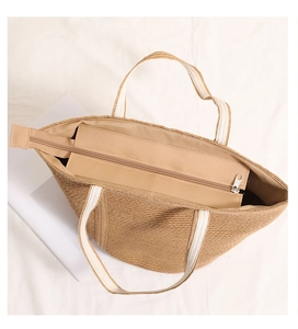 Detail view of woven straw tote bag with zipper closure and durable canvas handles