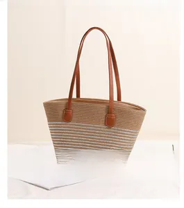 Side view of straw woven tote bag featuring striped patterns and brown leather handles