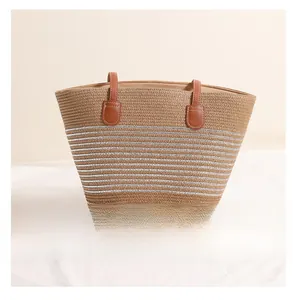 Close-up of khaki woven straw tote bag featuring silver metallic stripes and brown PU handles