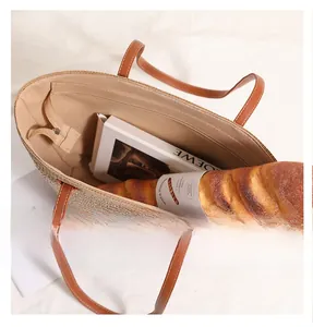 Detailed interior view of a straw tote bag showing the zipper pocket and large capacity